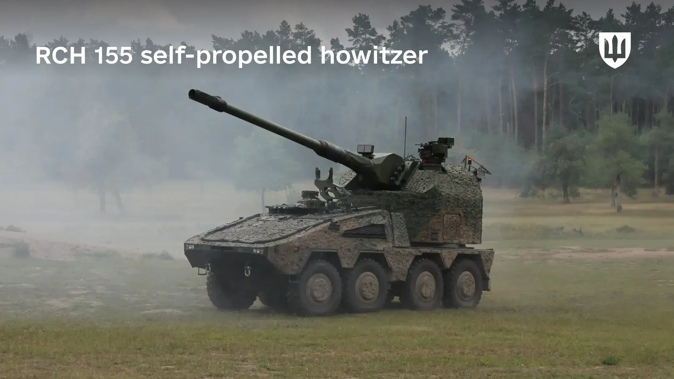 An RCH 155 self-propelled howitzer in open terrain with a forest covered in light mist in the background