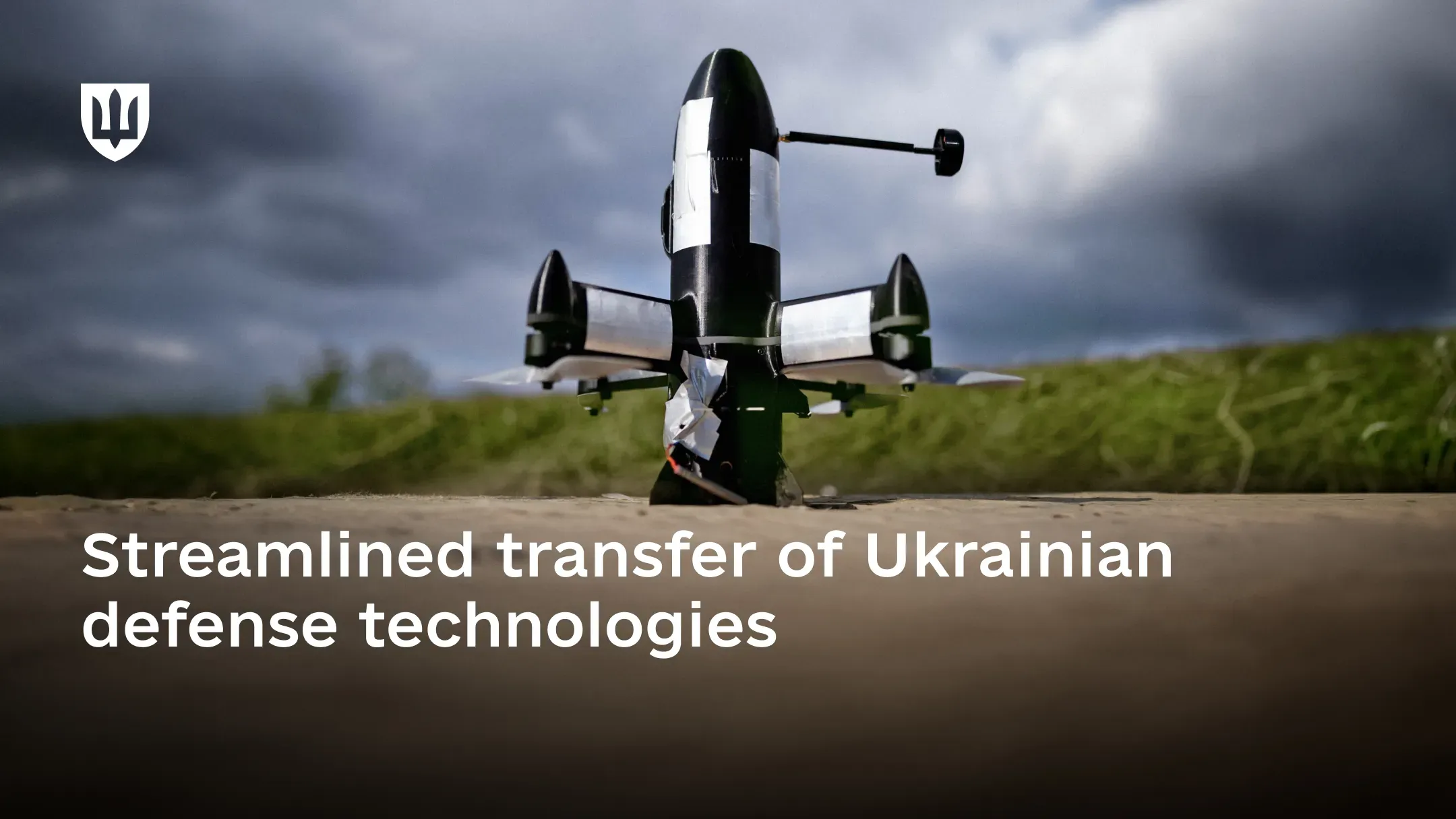 A black military drone with a vertical configuration stands on the ground in the foreground