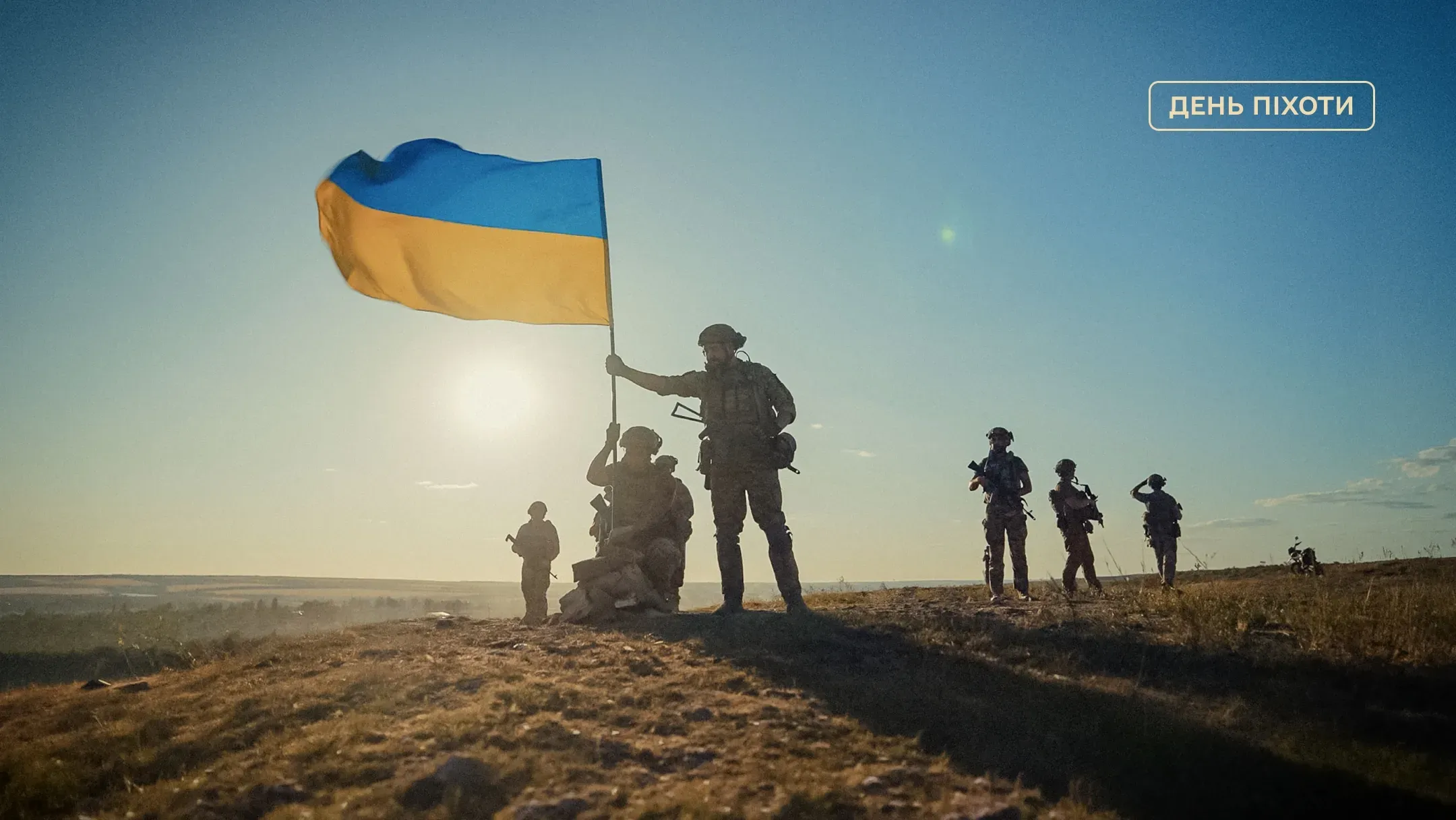 Українські піхотинці з національним прапором на пагорбі на світанку