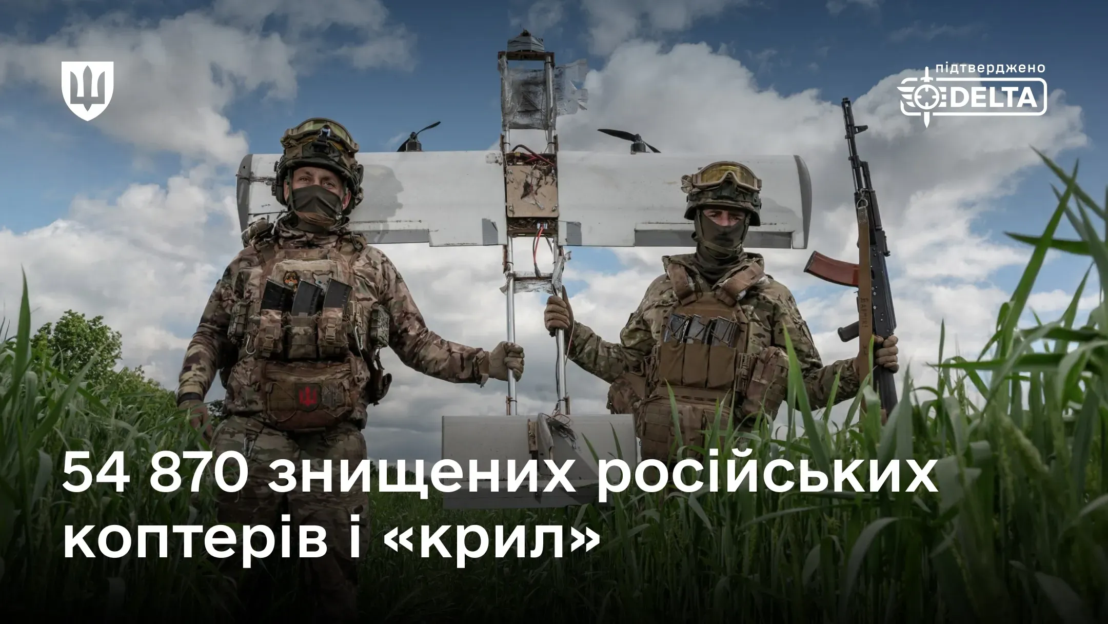 Двоє українських військовослужбовців тримають збитий безпілотник рф у полі