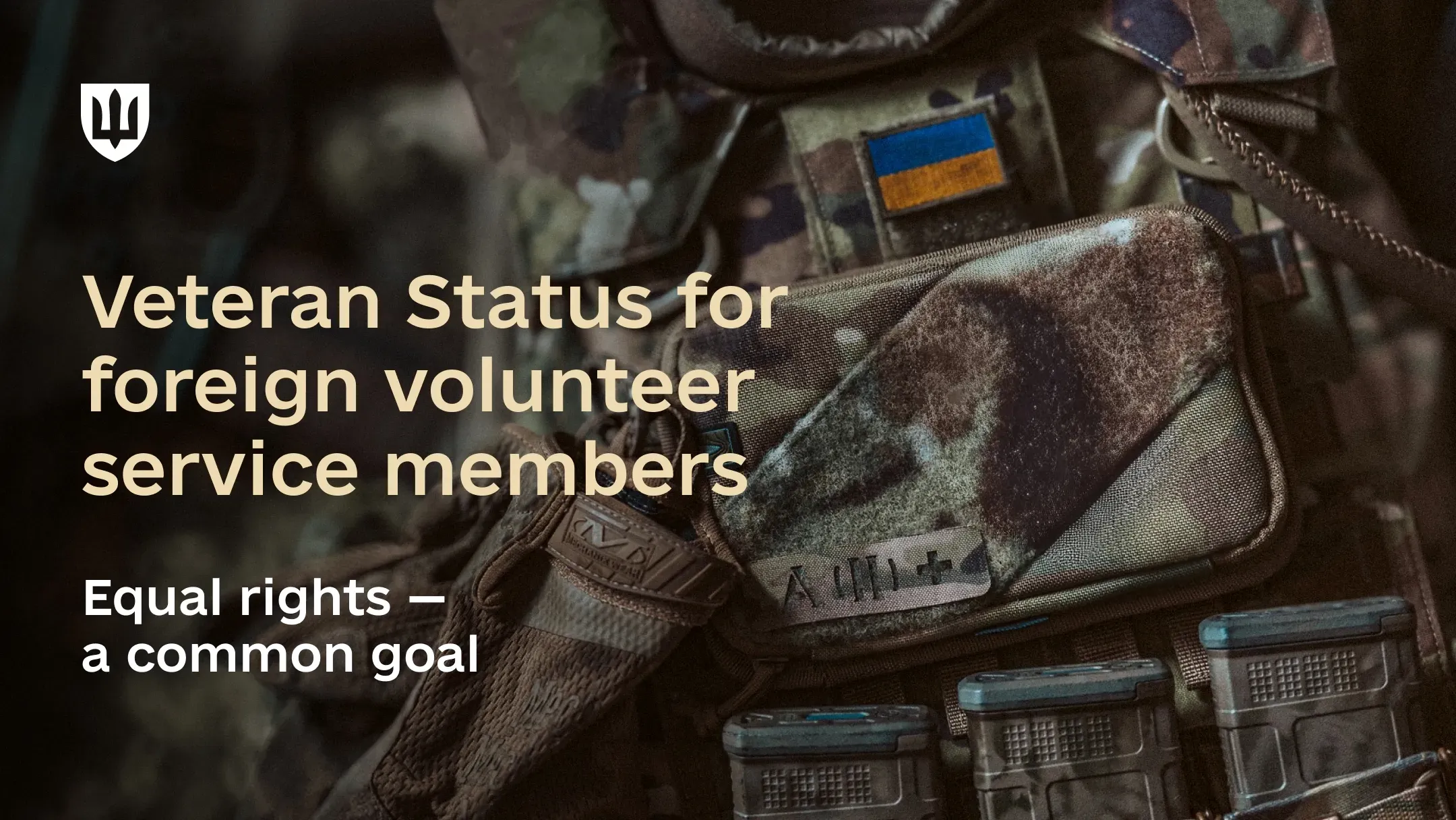 A hand holds a smartphone with a digital veteran ID displayed in the Diia app, with military gear in the background