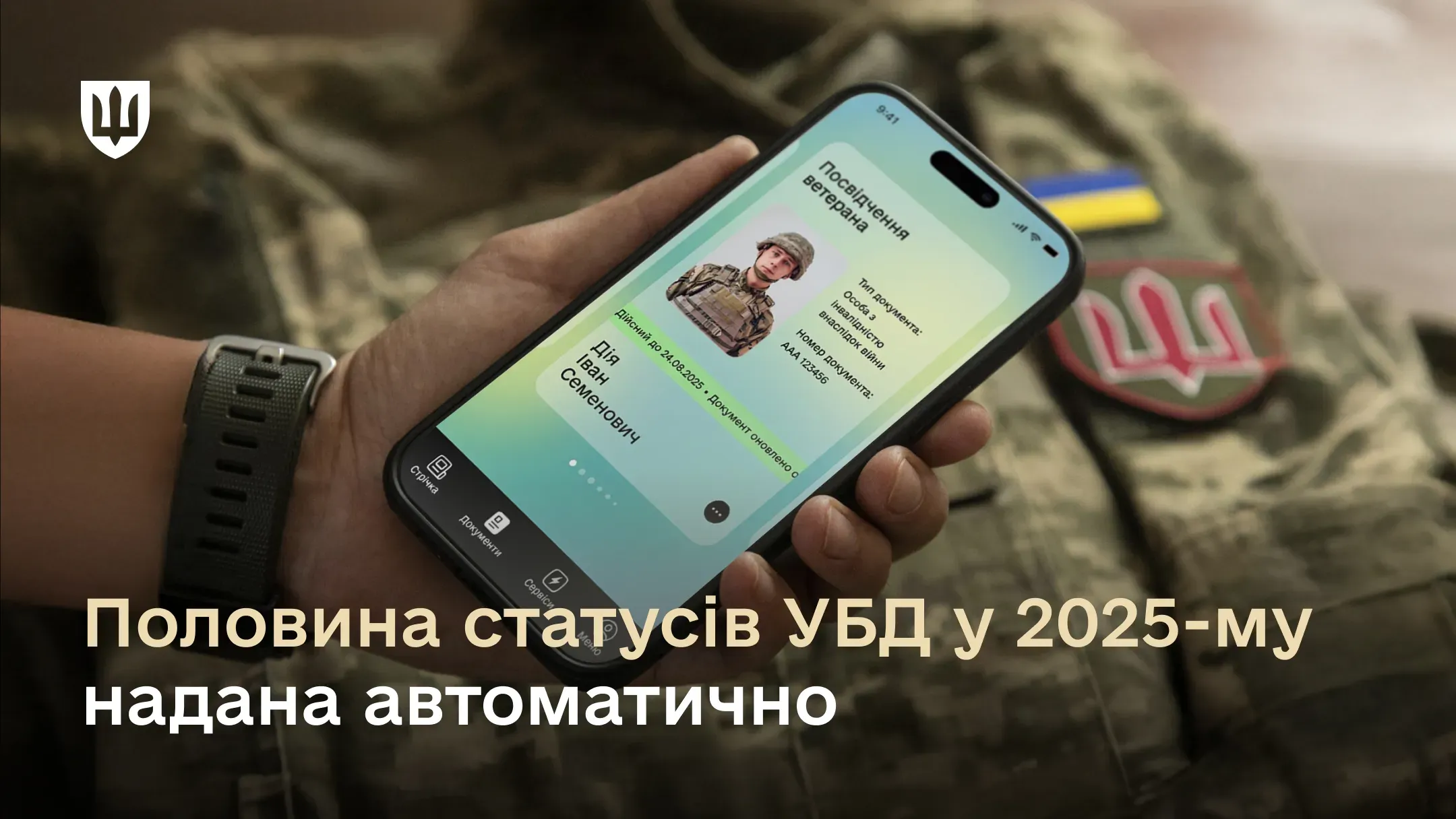 Смартфон у руці з відкритим електронним посвідченням ветерана в застосунку Дія на тлі військового рюкзака. Текст на зображенні: «Половина статусів УБД у 2025-му надана автоматично».