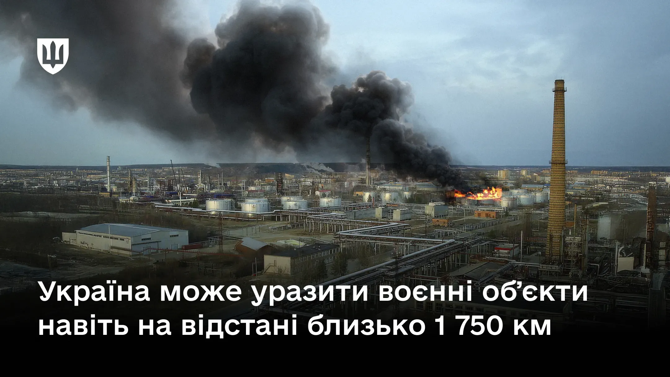 Панорамний вид на нафтопереробний завод під час пожежі з густим чорним димом.