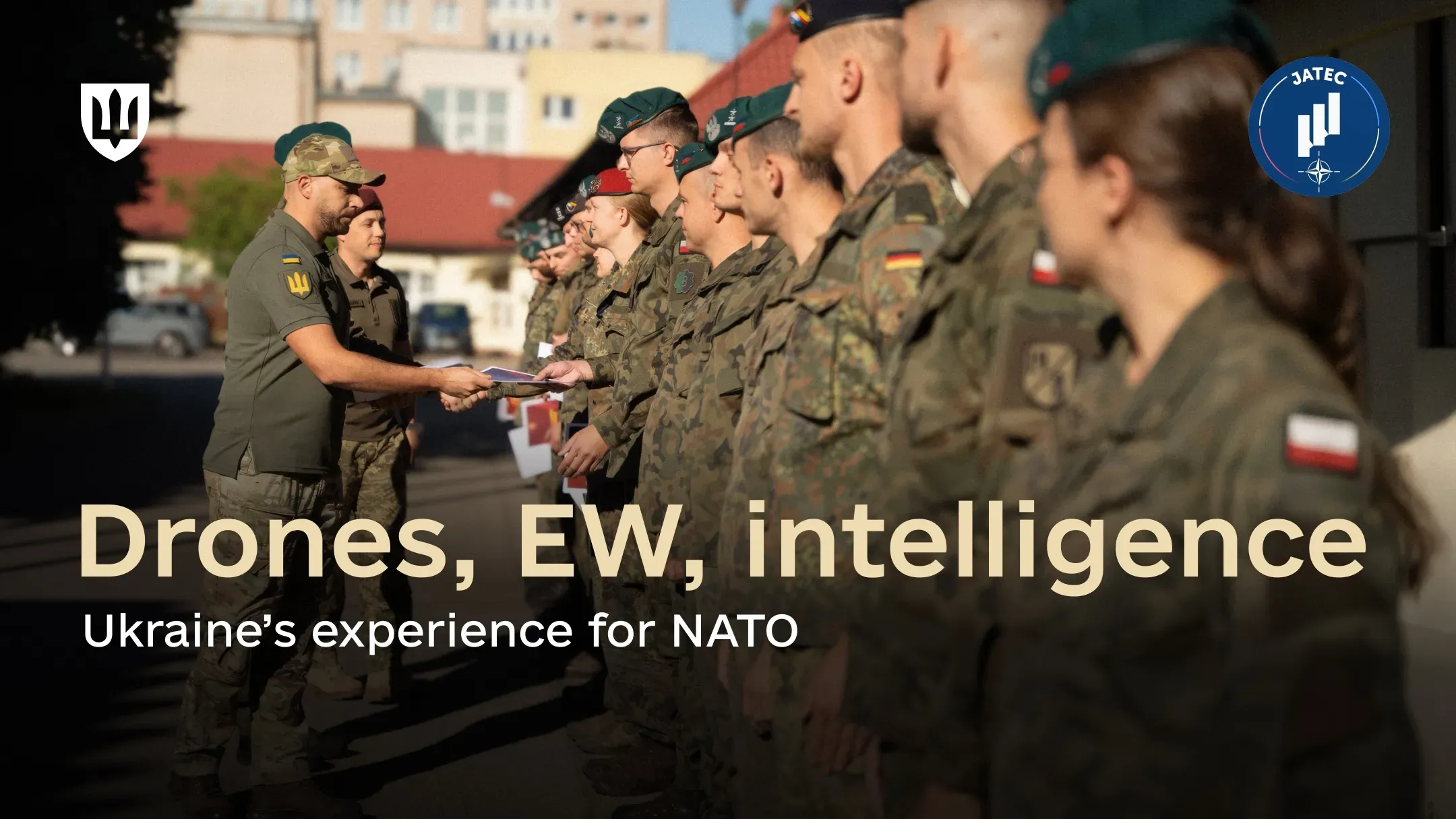 A Ukrainian service member handing a document to one of the foreign service members standing in formation