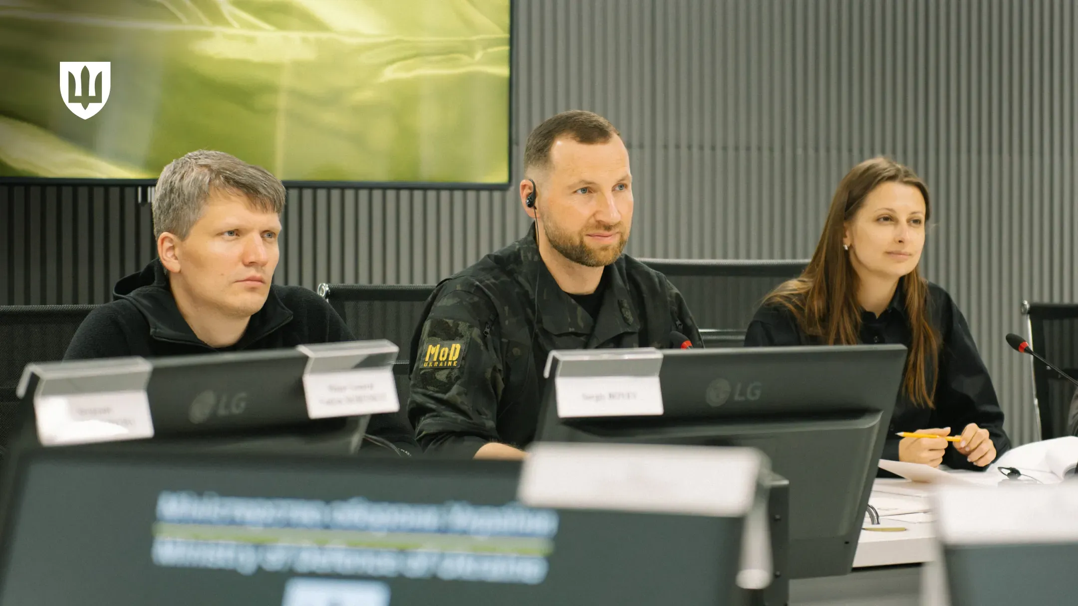 Євгеній Хмара, Сергій Боєв та Ганна Гвоздяр за столом переговорів перед моніторами та мікрофонами