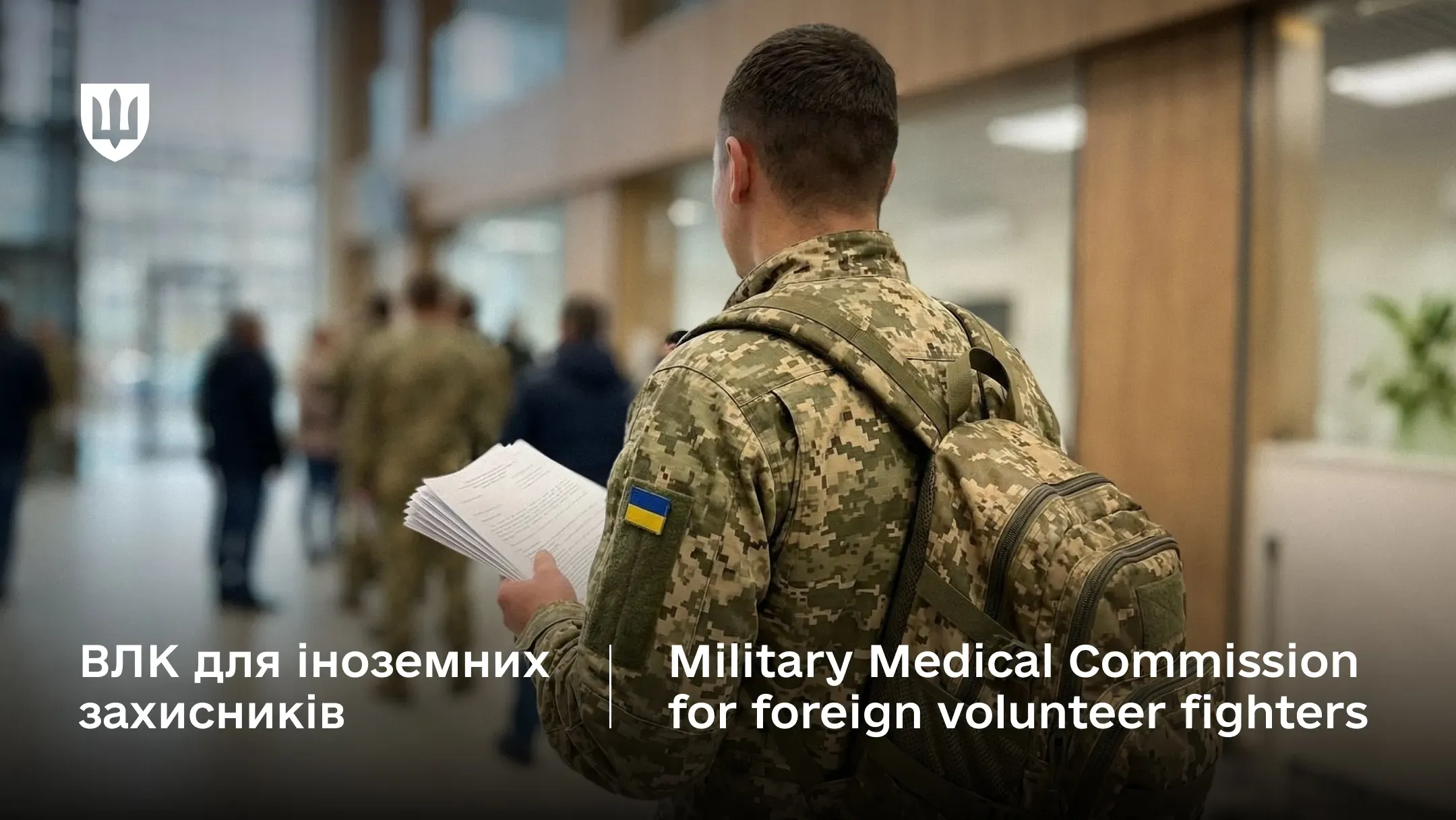 Військовослужбовець у піксельній формі зі шевроном України та з рюкзаком за плечима тримає документи для проходження військово-лікарської комісії