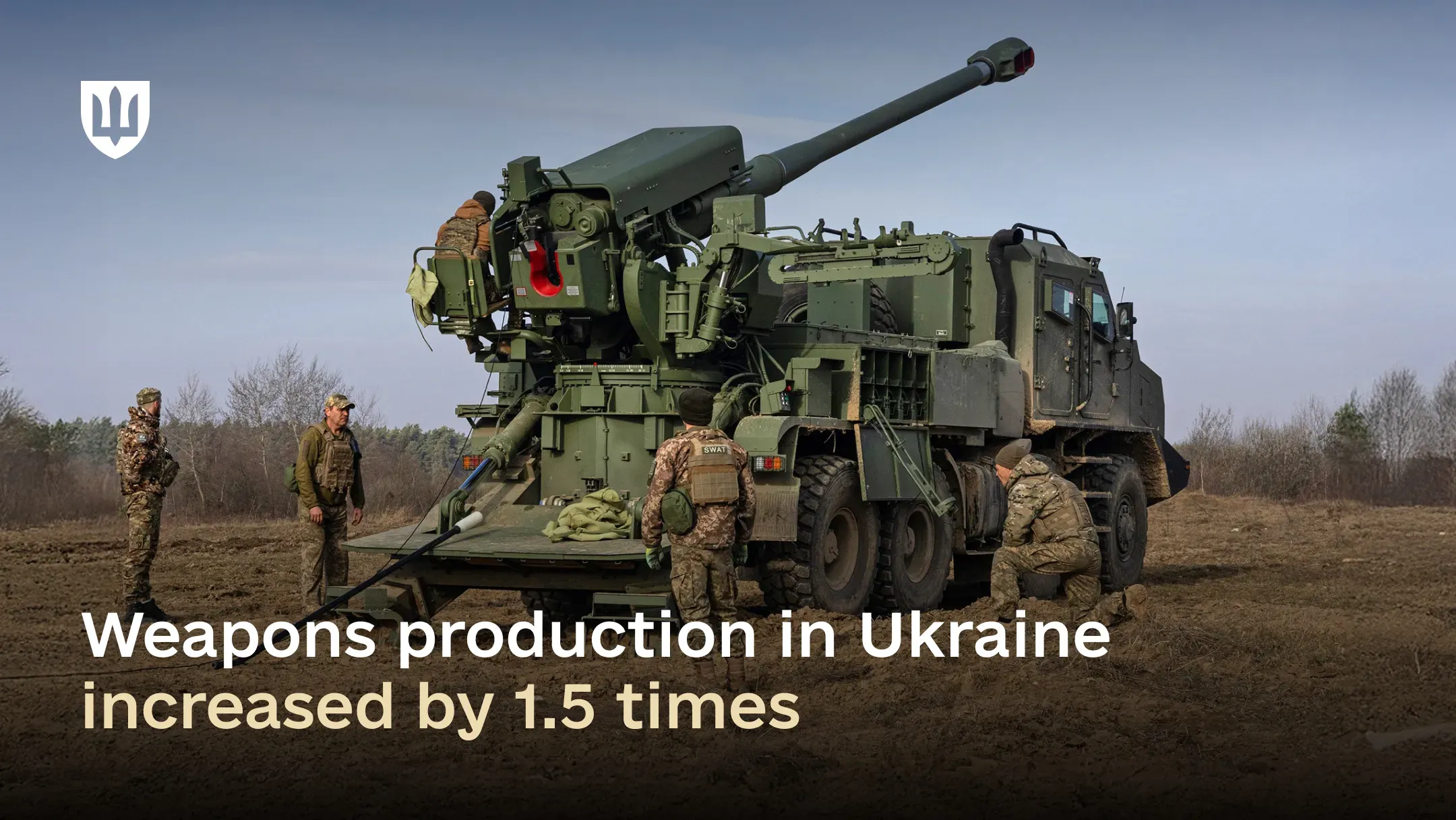 The Ukrainian-made “Bohdana” self-propelled artillery system at a firing position in an open field, with three Ukrainian service members in pixel camouflage uniforms nearby