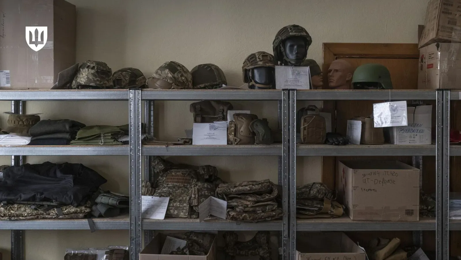 Військова форма на складі, стелажі з касками, куртками і штанами