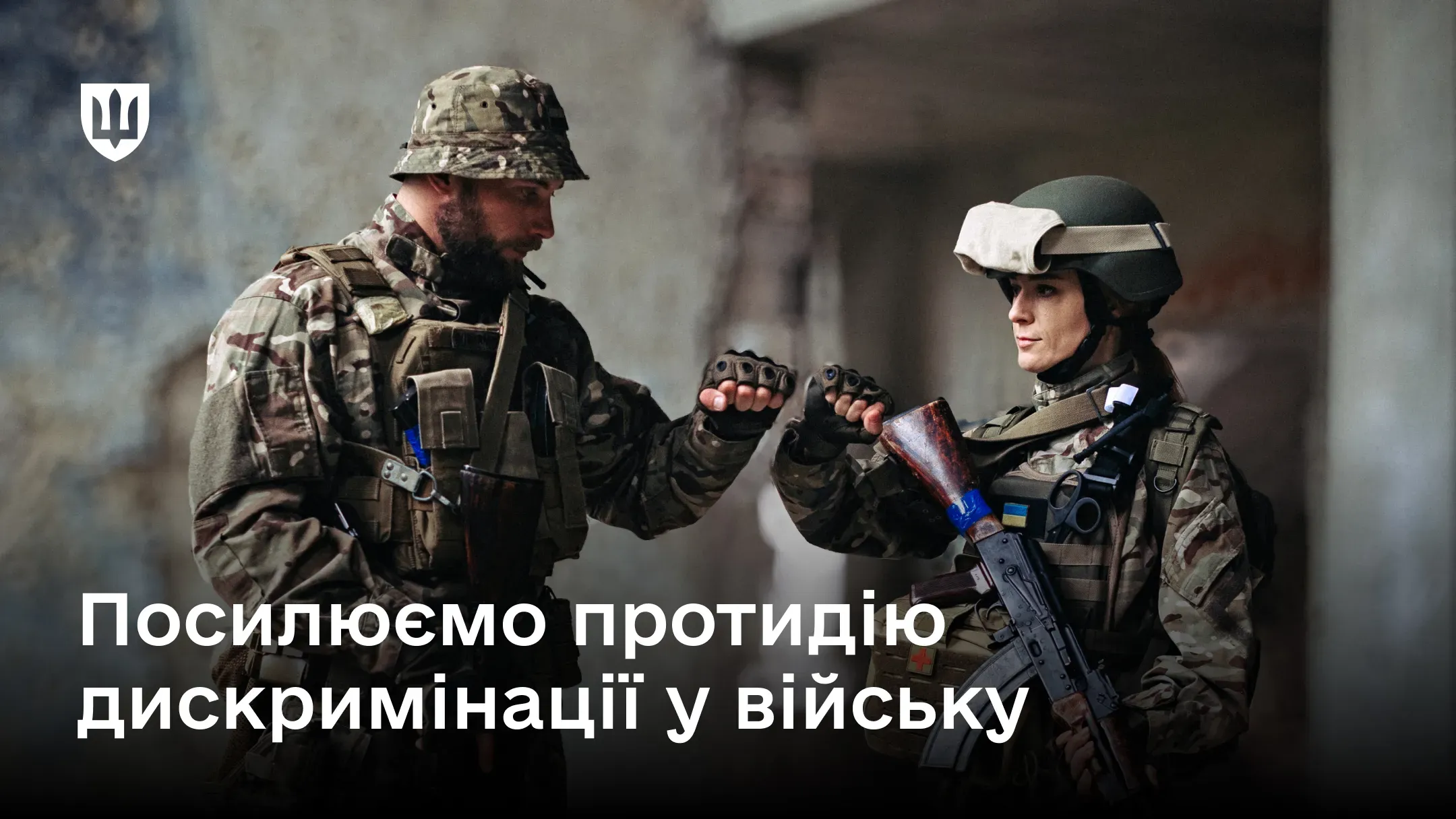 Двоє українських військовослужбовців – чоловік і жінка у військовій формі – торкаються кулаками на тлі зруйнованої будівлі; на зображенні також розміщено напис про протидію дискримінації у війську